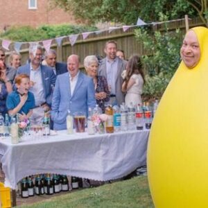 Danny the Idiot in a yellow giant balloon with family of all generations laughing.