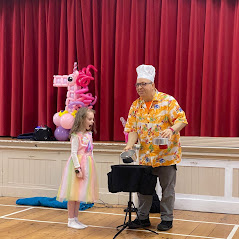 7th Birthday girl on stage with Danny the Idiot, helping to make a magical cake.