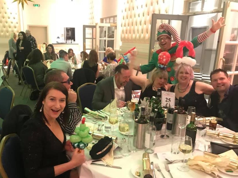 Corporate Event Christmas party with Danny the Elf and adults with balloons.